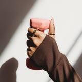 Hand holding a pink object with a blurred background