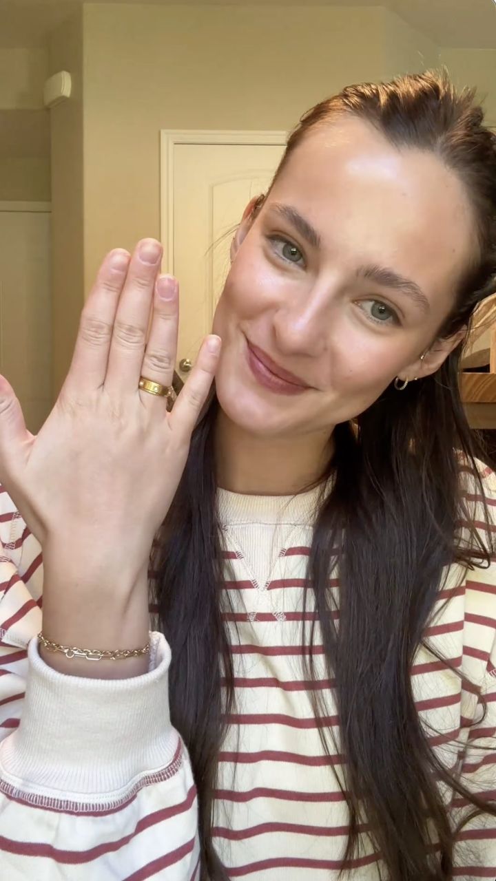 Smiling customer showing her Anxi Rings in a striped sweater