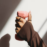 Hand holding a pink object with a blurred background
