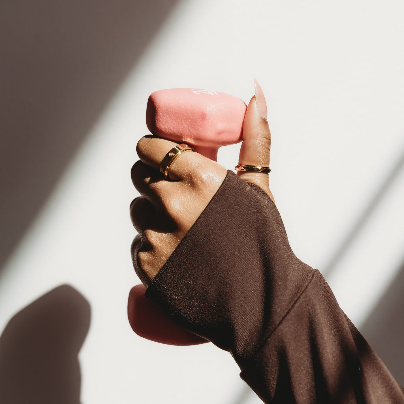 Hand holding a pink object with a blurred background