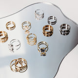 Collection of gold and silver rings on a reflective surface