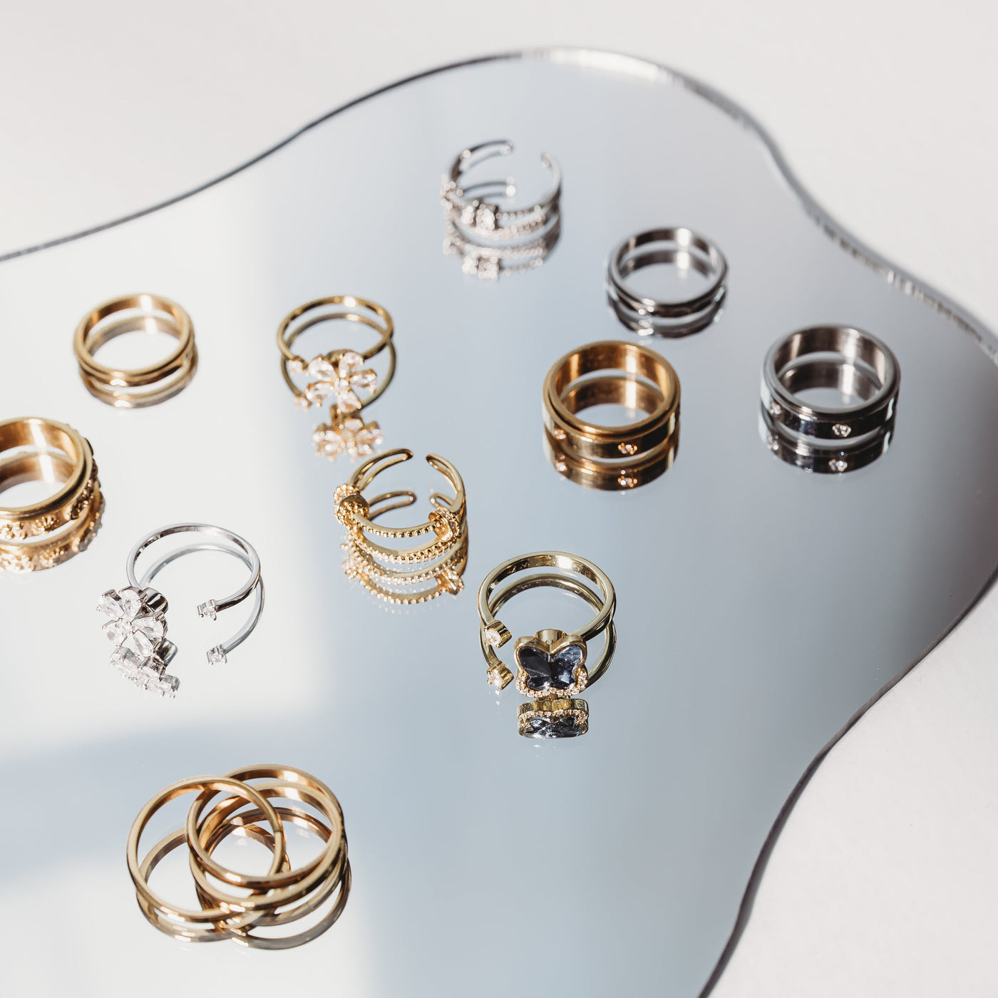 Collection of gold and silver rings on a reflective surface
