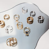 Collection of gold and silver rings on a reflective surface