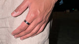 Hand wearing a watch with a blurred background