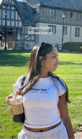 Woman holding a drink in front of a historic building with text overlay.