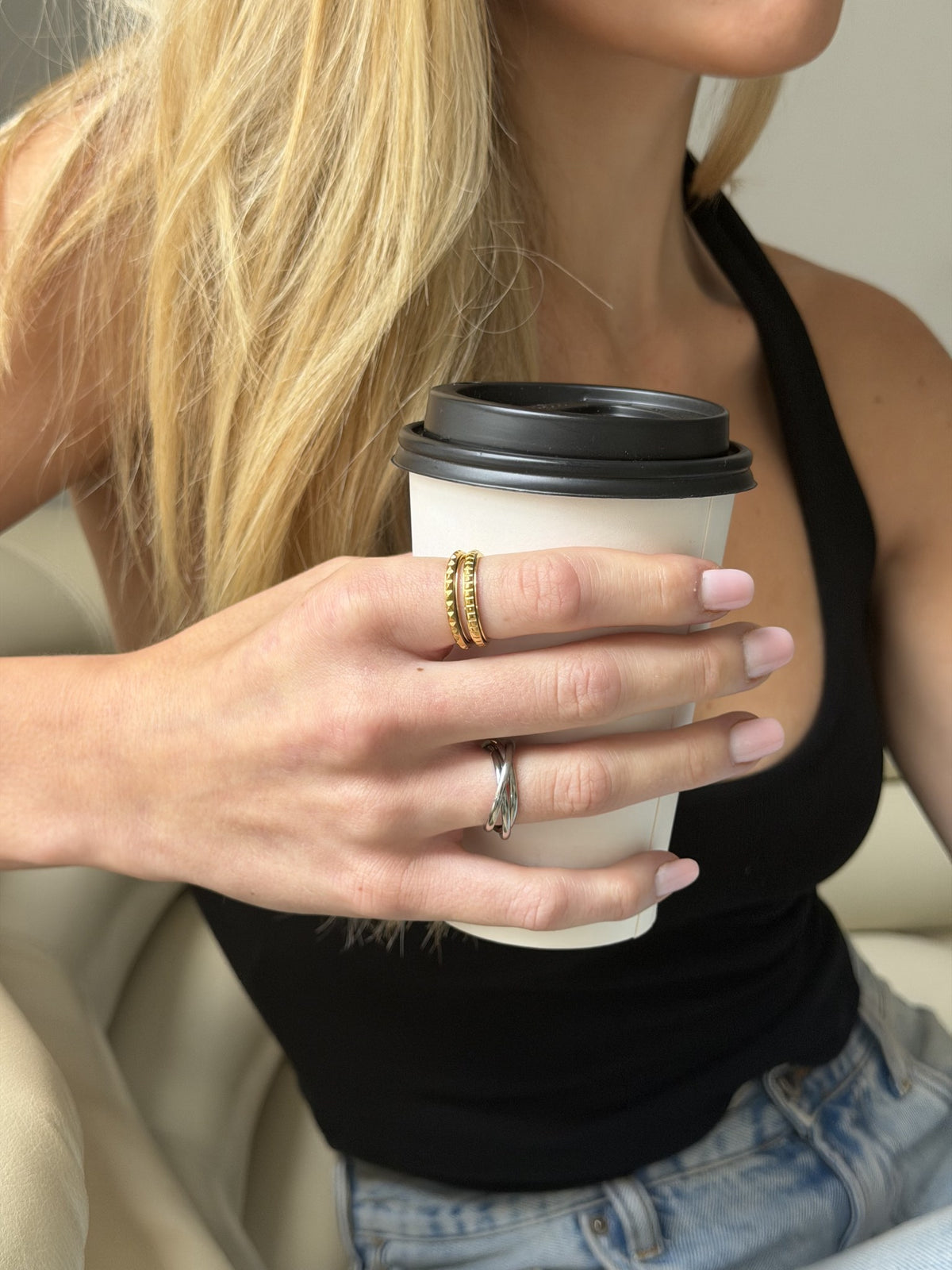 Above It All Rotator Anxi Ring worn while holding a coffee cup