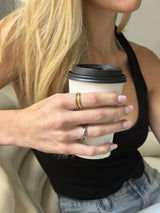 Above It All Rotator Anxi Ring worn while holding a coffee cup