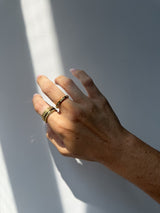 Close-up of the Tell Me More Rotator Anxi Ring in gold, showing the studded band in sunlight