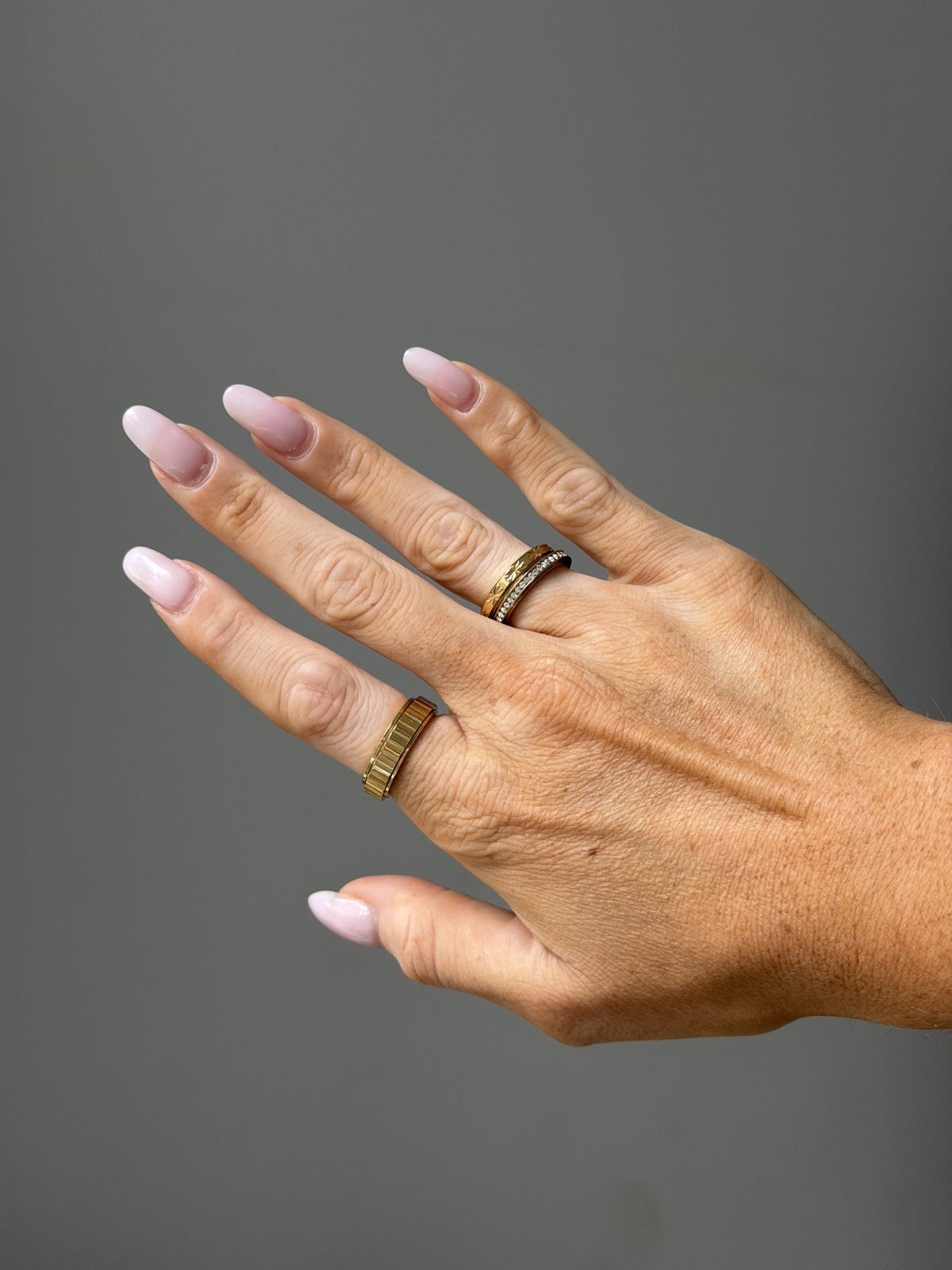 Close-up of the Love Letters Rotator Anxi Ring in gold, showing the engraved floral band