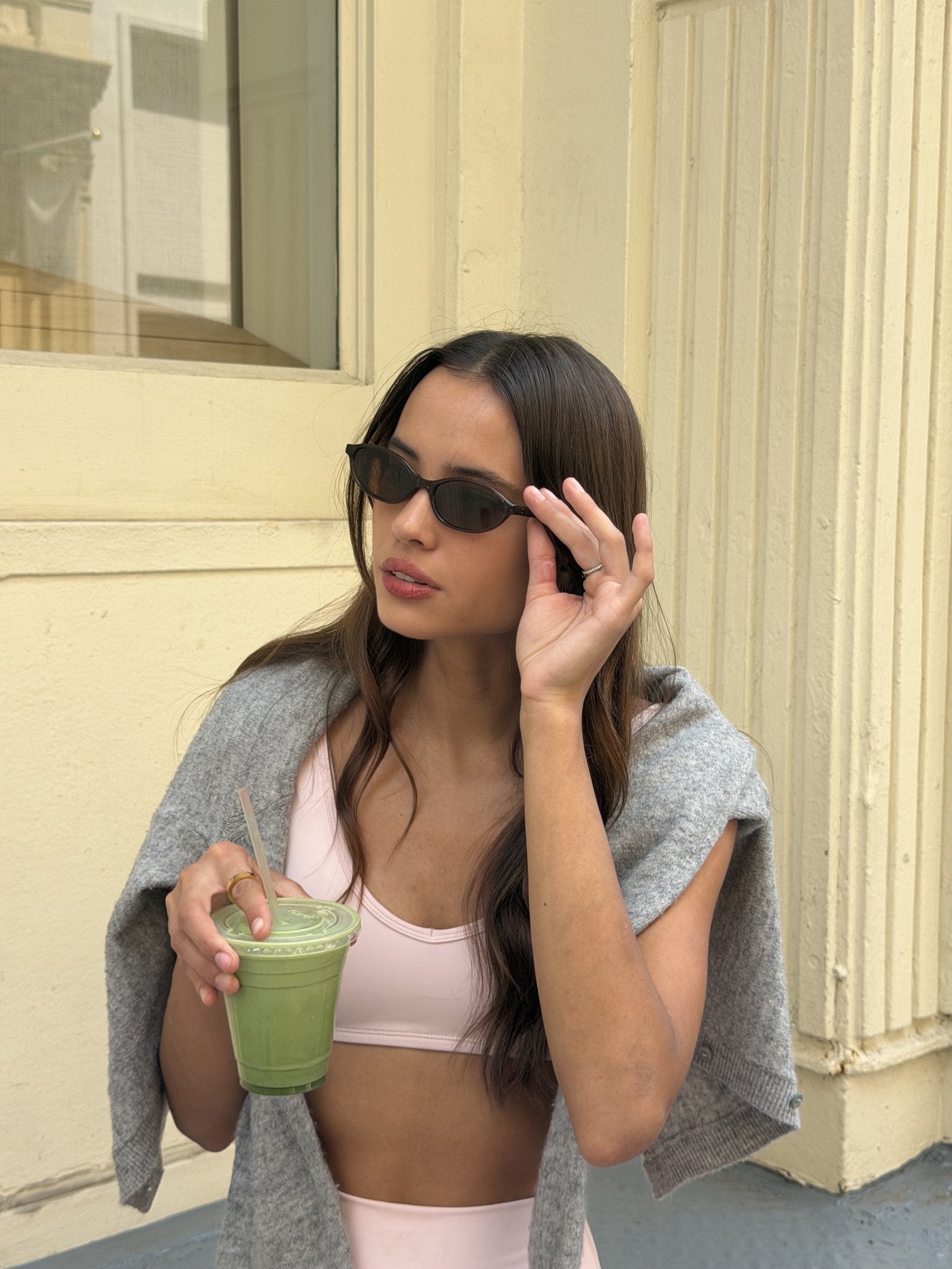 Woman in sunglasses on a city street, gold Anxi Rings catching the light