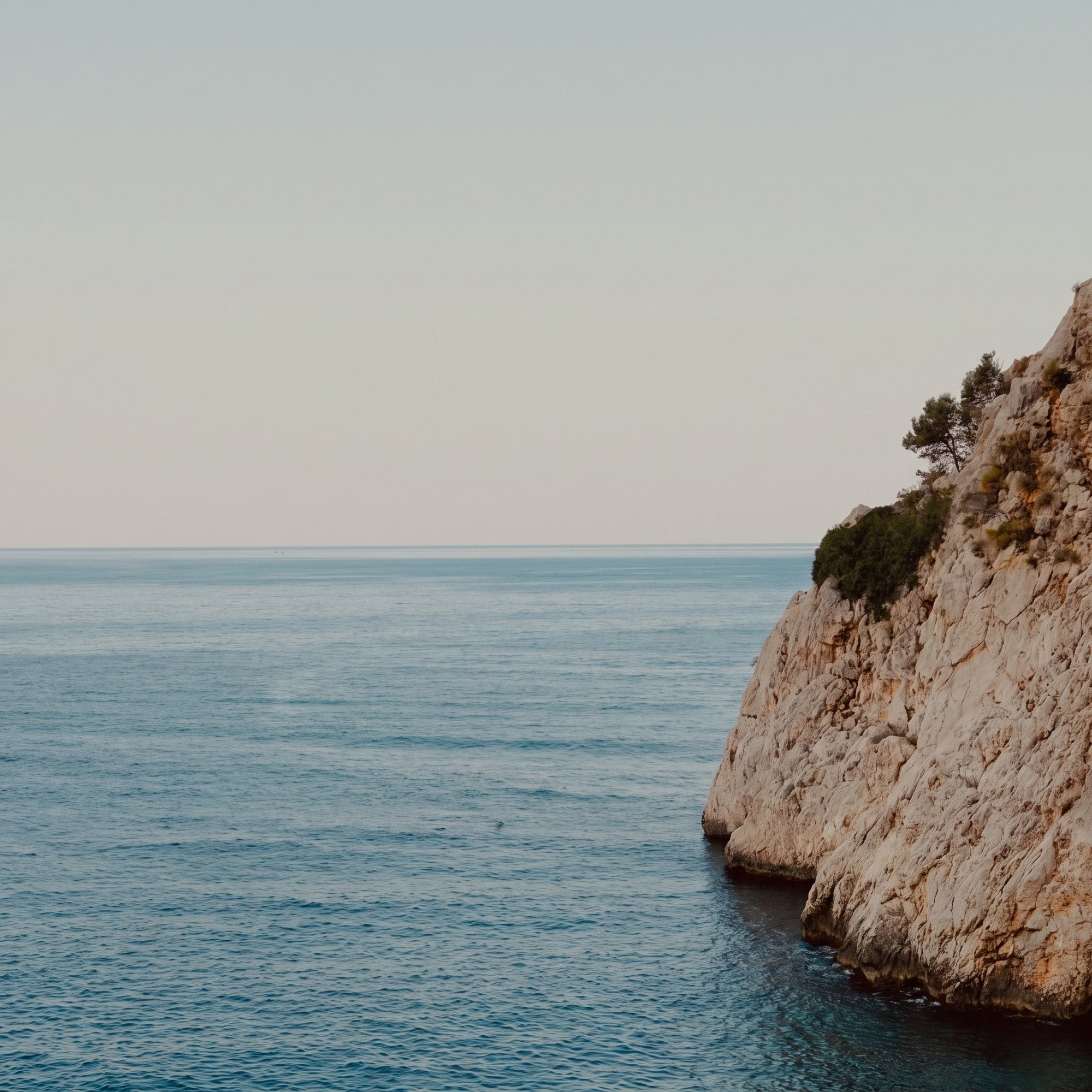Calm sea and limestone cliff at golden hour
