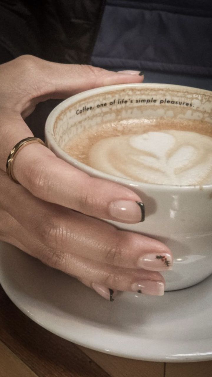 Hands with gold Anxi Rings around a latte