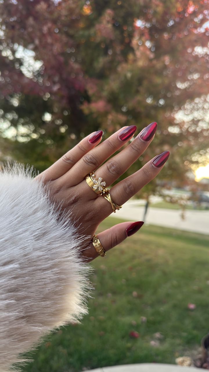 Hand with gold Anxi Rings against fall leaves and a fur cuff