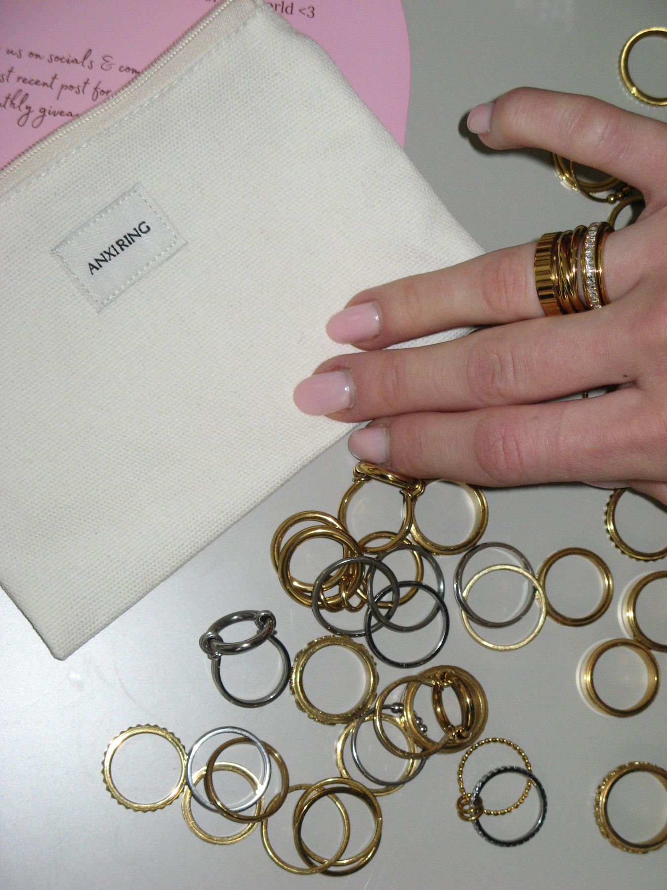 A pile of gold and silver Anxi Rings spilling from an Anxi Ring pouch